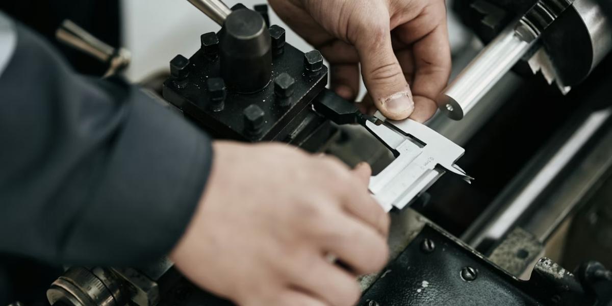 Precision inspector measuring machined part with vernier caliper on CNC lathe — in-process dimensional inspection at VNcontX Vietnam for Australian export orders